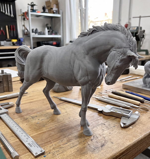 Prototype gris d’une sculpture de cheval imprimé en 3D et contrôlé dans un atelier