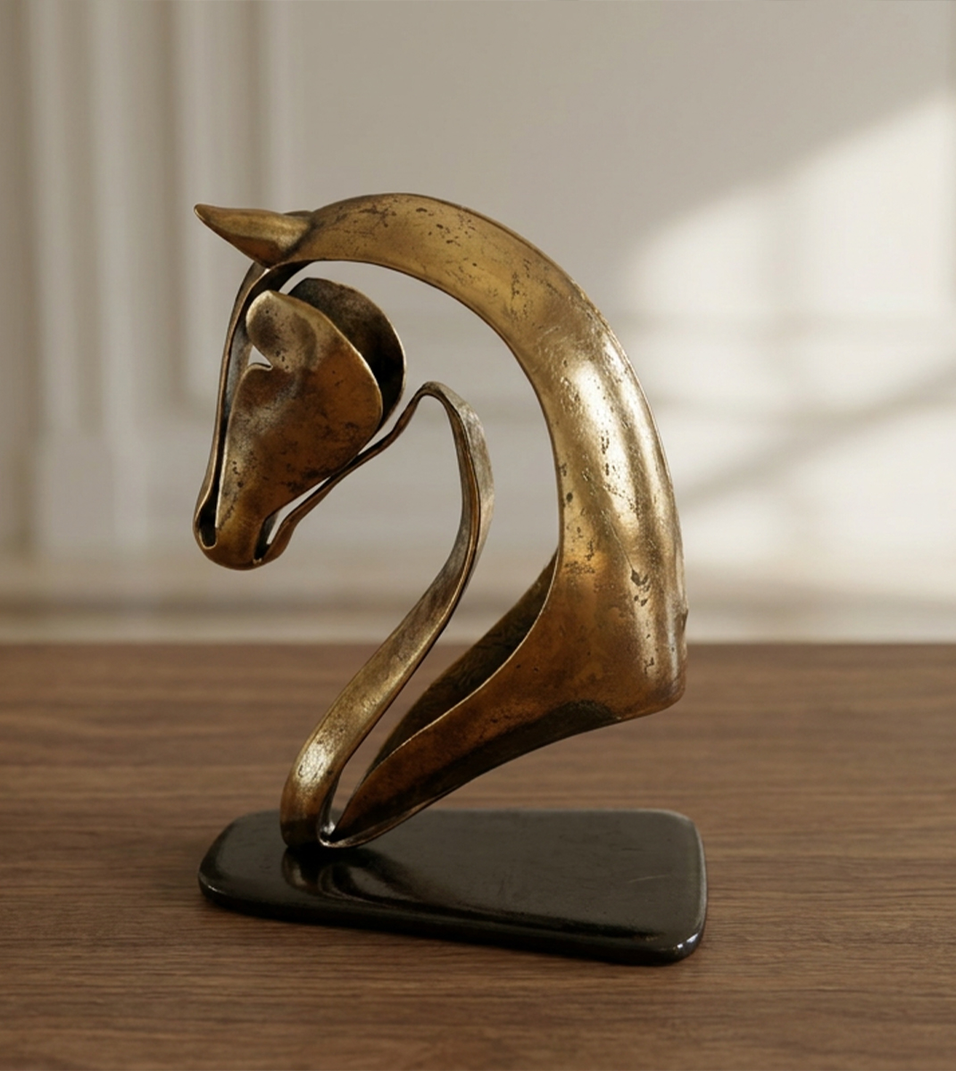 Sculpture abstraite de tête de cheval en finition bronze patiné présentée sur un socle noir